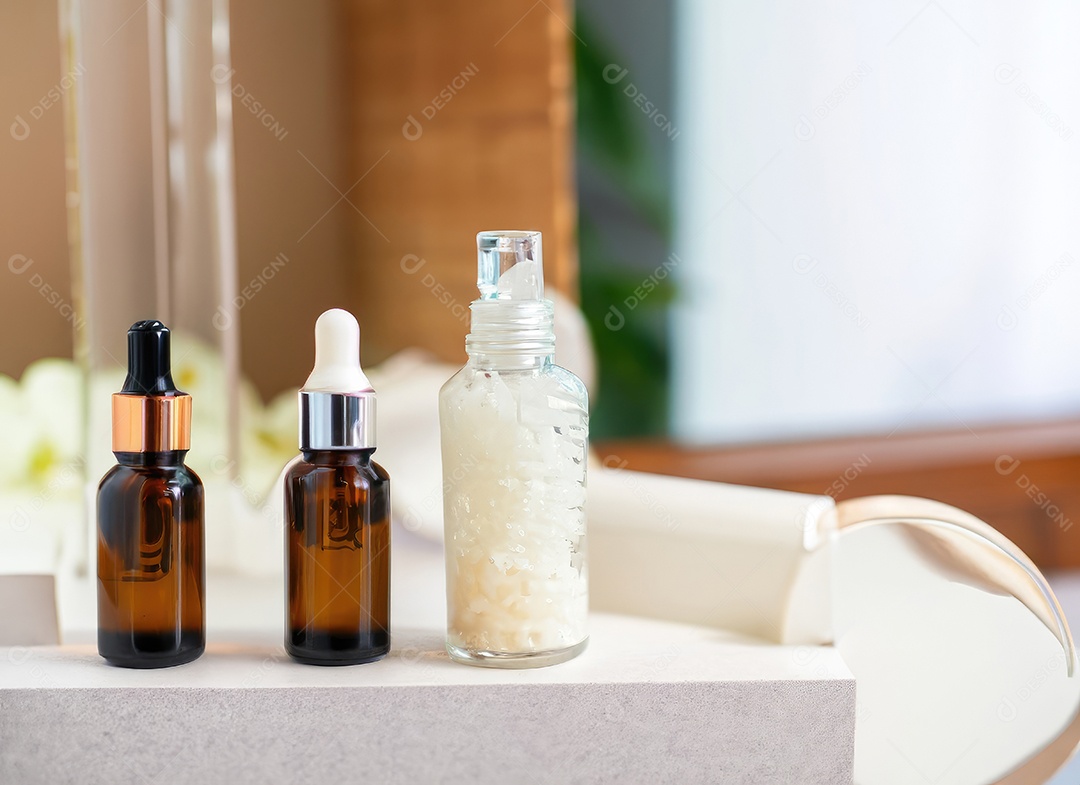 Garrafas no fundo da sala de spa. Soro de cuidados com a pele ou cosméticos naturais com óleo essencial.