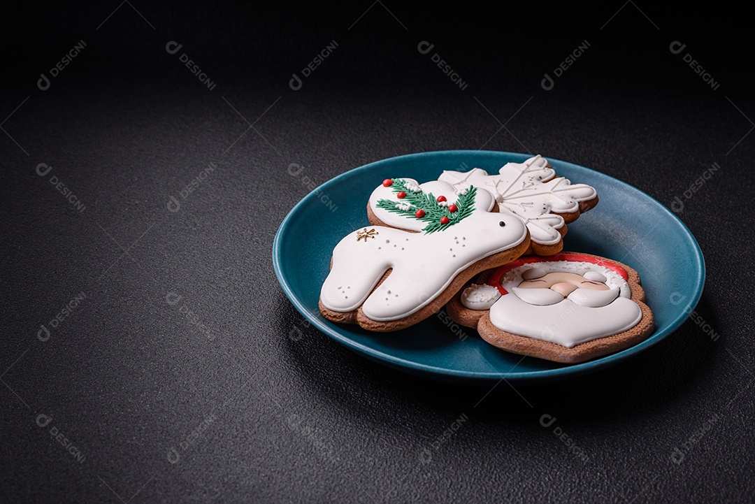 Lindos biscoitos de gengibre de Natal em uma placa cerâmica redonda sobre um fundo de concreto texturizado