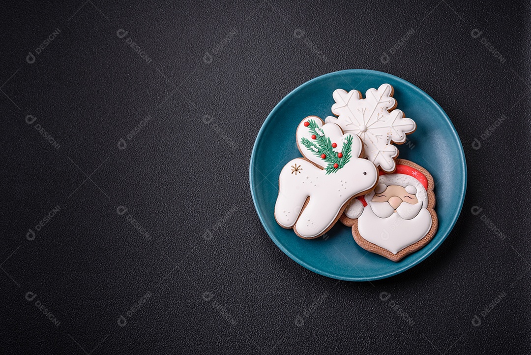 Lindos biscoitos de gengibre de Natal em uma placa cerâmica redonda sobre um fundo de concreto texturizado