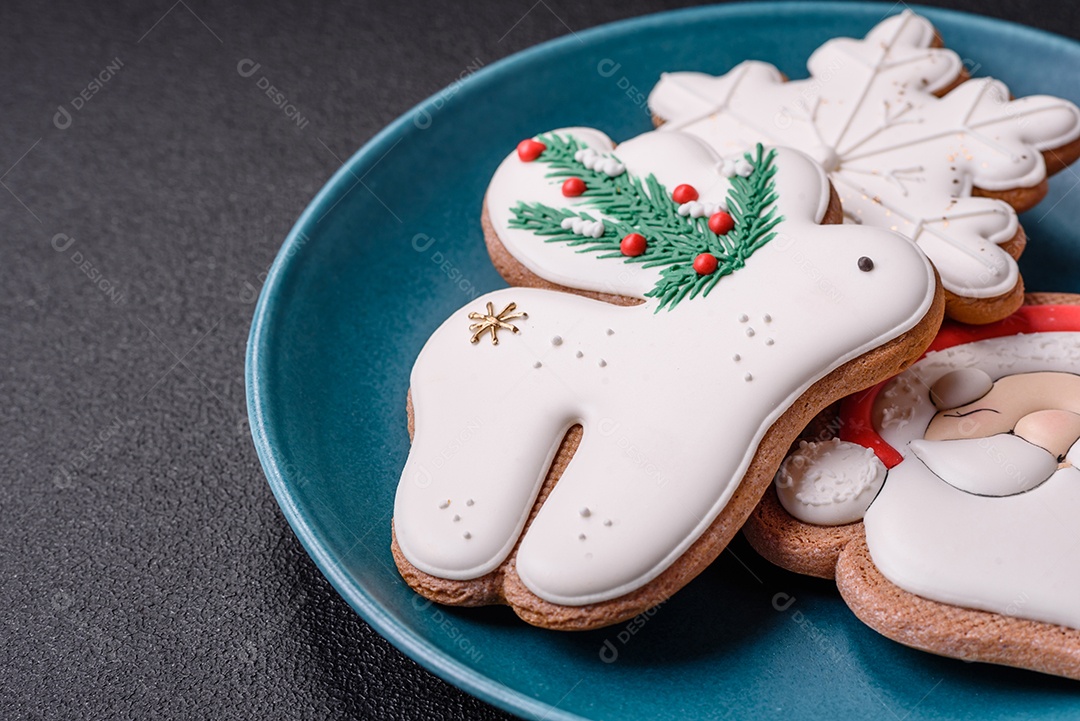 Lindos biscoitos de gengibre de Natal em uma placa cerâmica redonda sobre um fundo de concreto texturizado