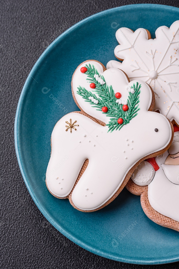 Lindos biscoitos de gengibre de Natal em uma placa cerâmica redonda sobre um fundo de concreto texturizado