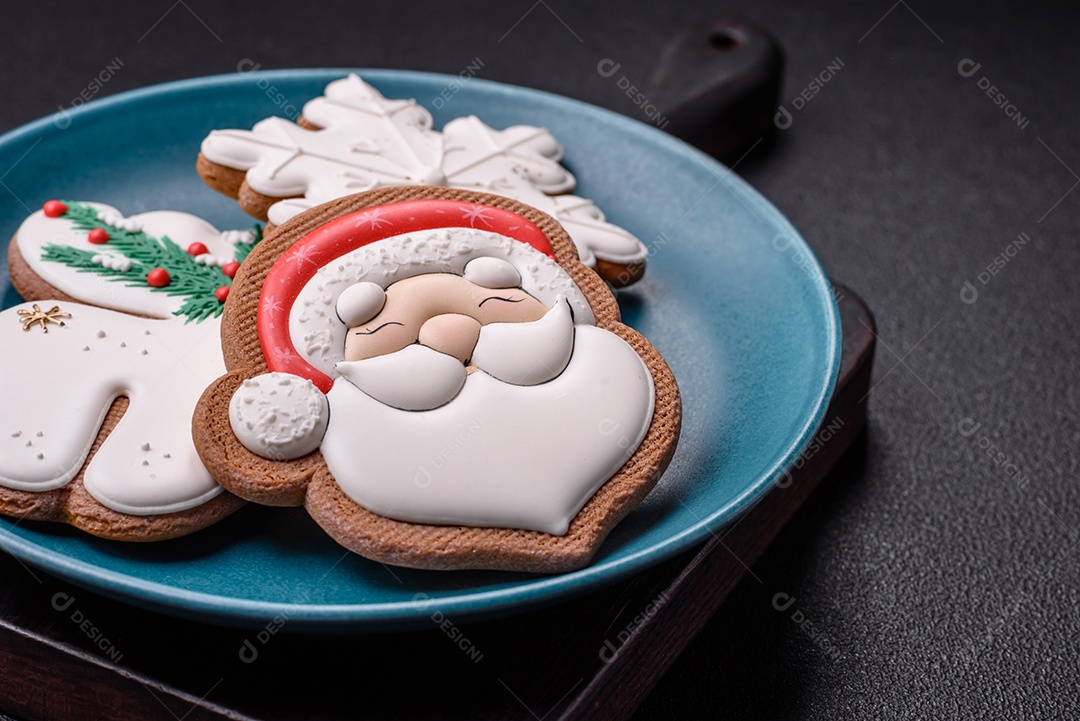 Lindos biscoitos de gengibre de Natal em uma placa cerâmica redonda sobre um fundo de concreto texturizado