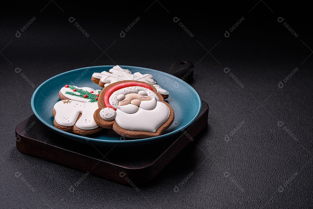 Lindos biscoitos de gengibre de Natal em uma placa cerâmica redonda sobre um fundo de concreto texturizado