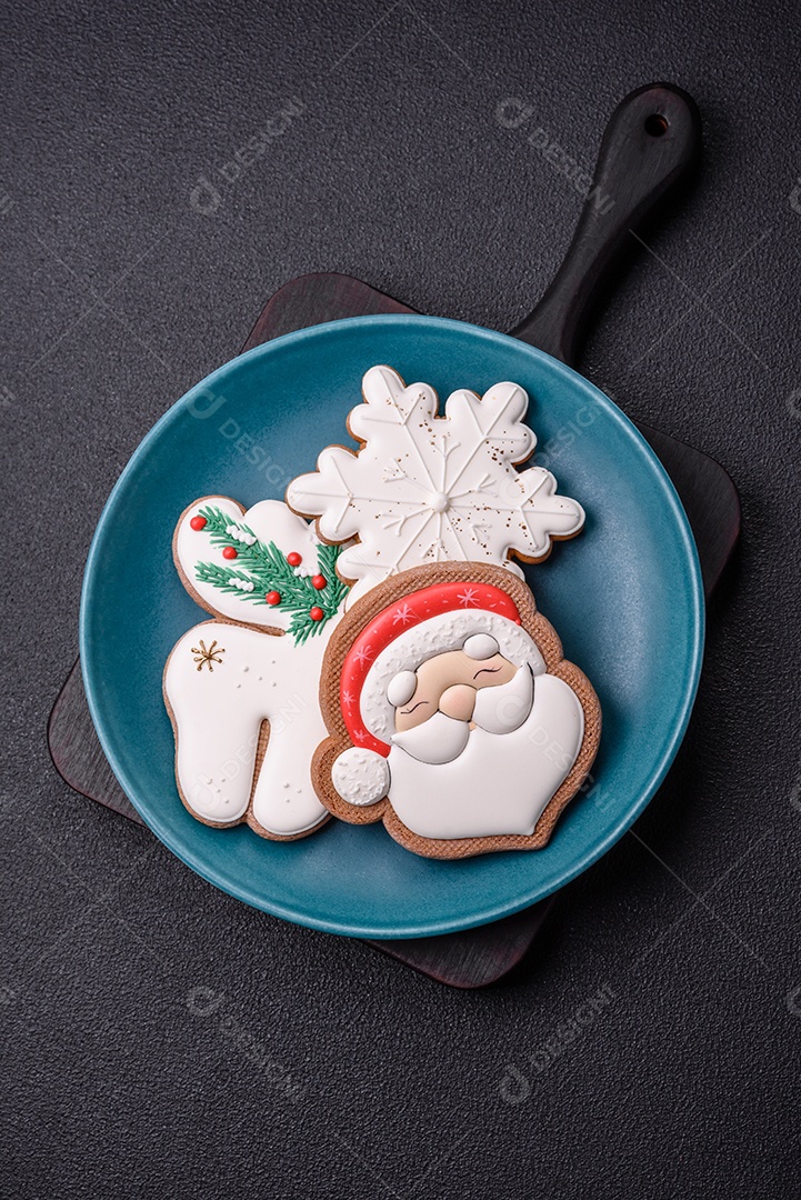 Lindos biscoitos de gengibre de Natal em uma placa cerâmica redonda sobre um fundo de concreto texturizado