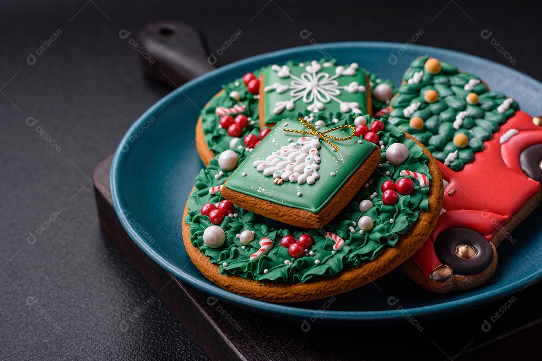 Lindos biscoitos de gengibre de Natal em uma placa cerâmica redonda sobre um fundo de concreto texturizado