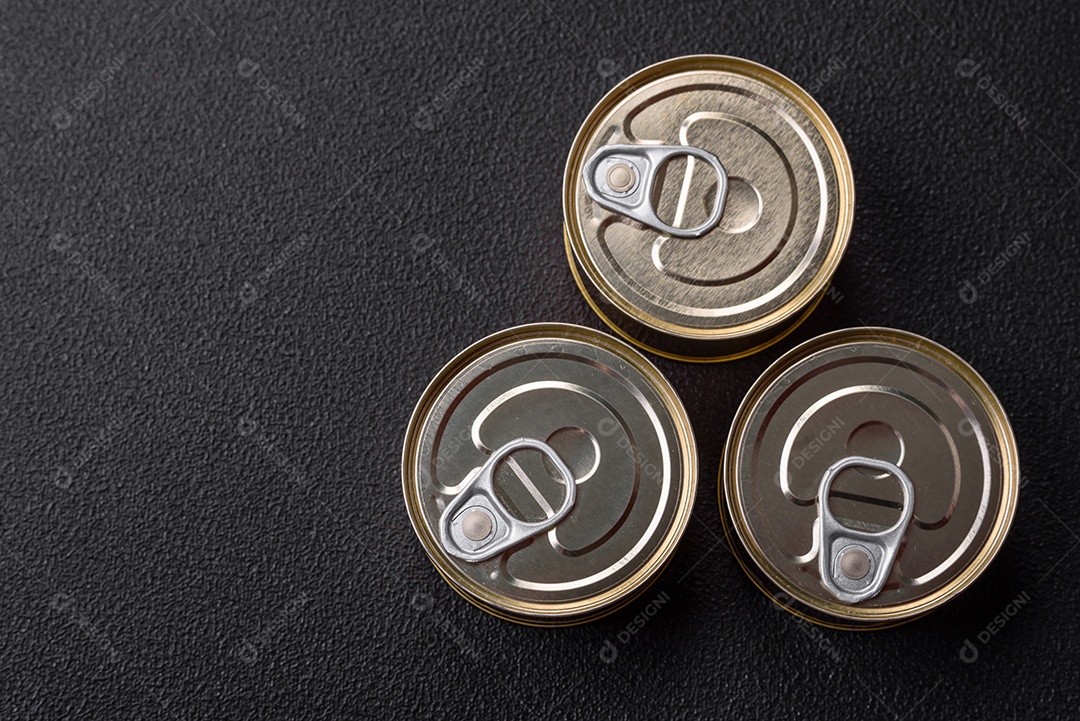 Lata redonda de metal com conservas de peixe ou carne com chave sobre fundo de textura de concreto