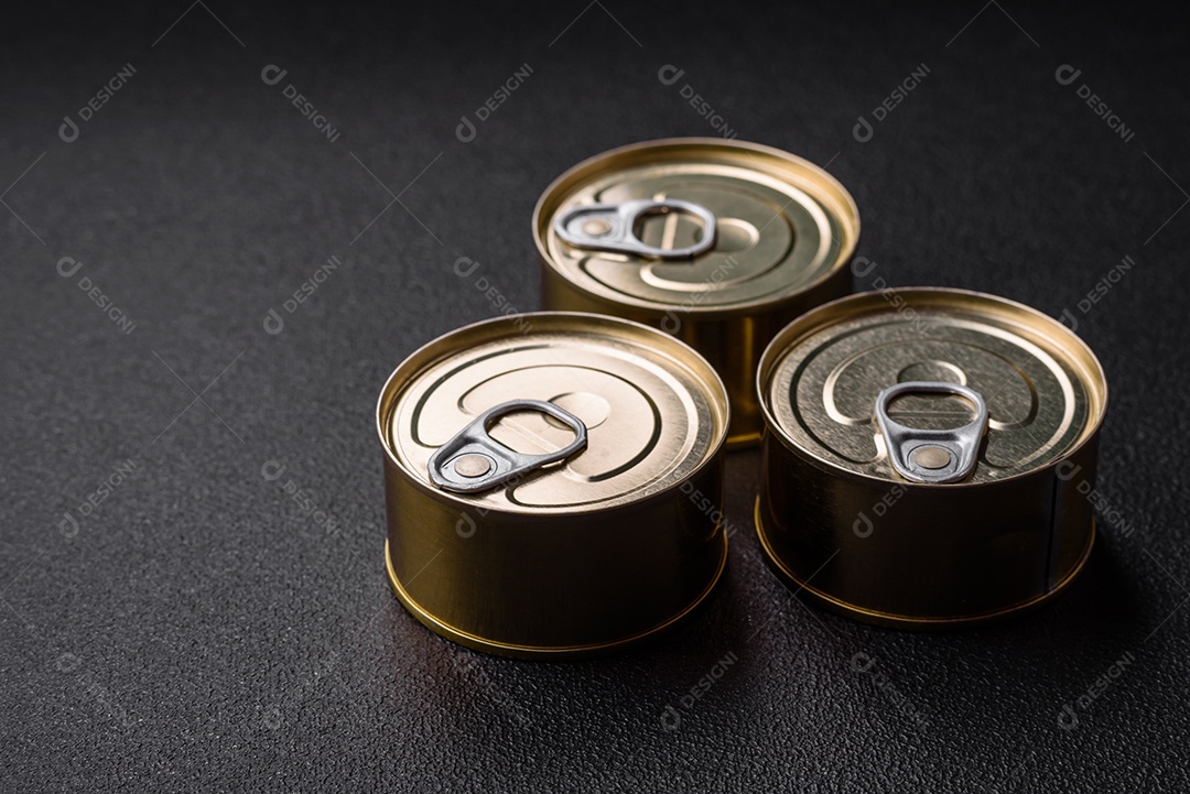 Lata redonda de metal com conservas de peixe ou carne com chave sobre fundo de textura de concreto