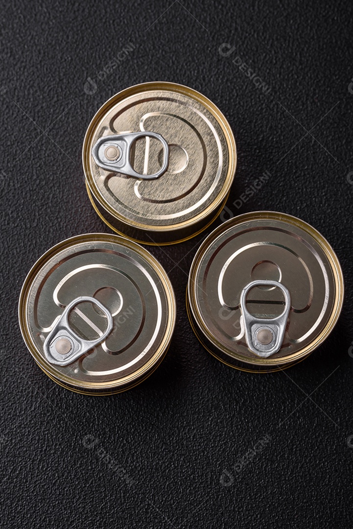 Lata redonda de metal com conservas de peixe ou carne com chave sobre fundo de textura de concreto