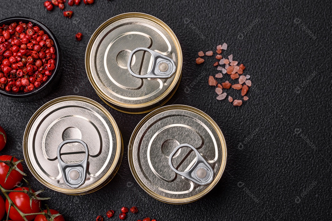 Lata redonda de metal com conservas de peixe ou carne com chave sobre fundo de textura de concreto