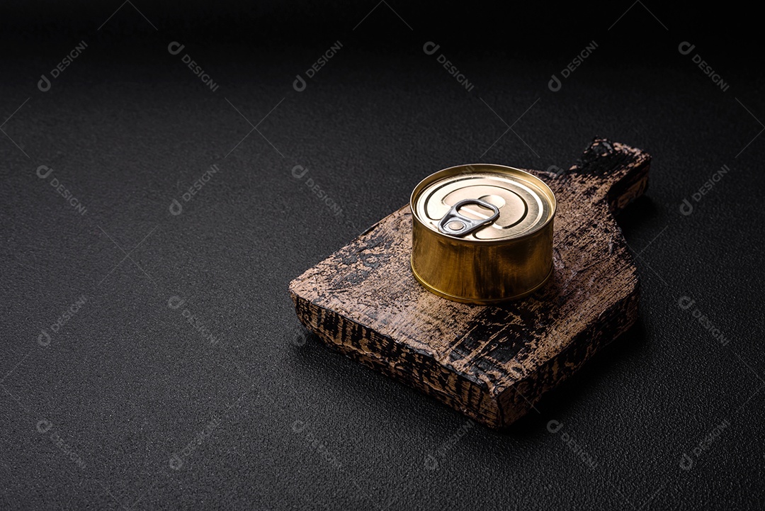 Lata redonda de metal com conservas de peixe ou carne com chave sobre fundo de textura de concreto