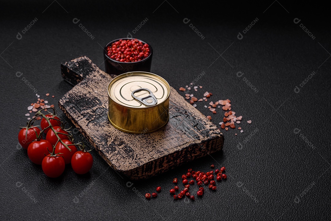 Lata redonda de metal com conservas de peixe ou carne com chave sobre fundo de textura de concreto