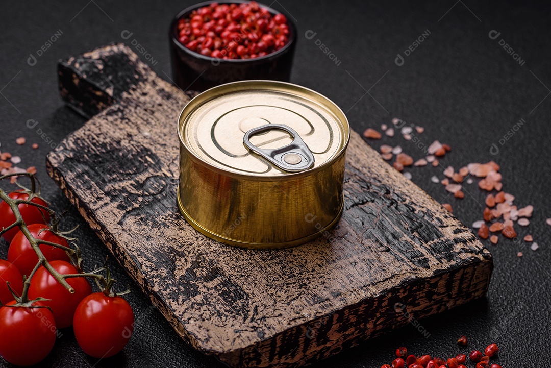 Lata redonda de metal com conservas de peixe ou carne com chave sobre fundo de textura de concreto