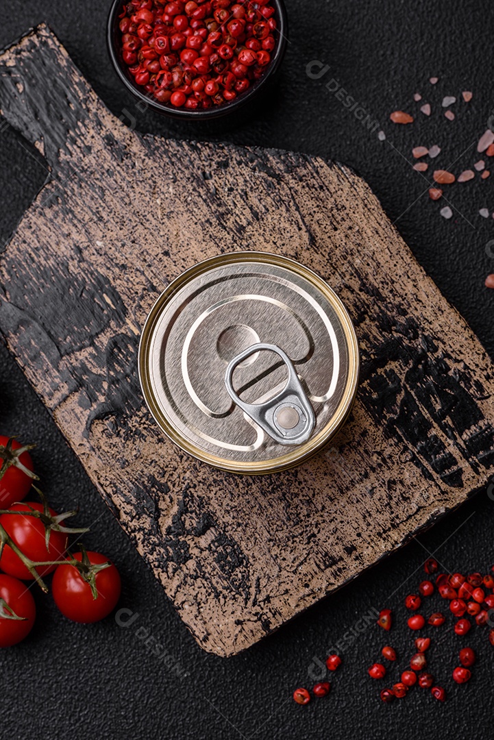 Lata redonda de metal com conservas de peixe ou carne com chave sobre fundo de textura de concreto