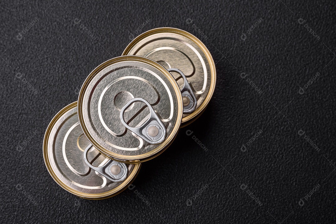 Lata redonda de metal com conservas de peixe ou carne com chave sobre fundo de textura de concreto