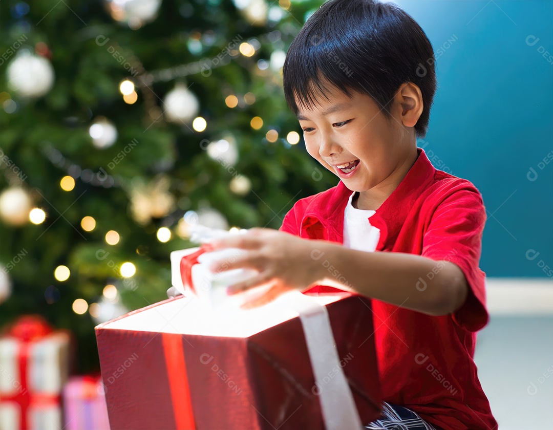 Criança asiática feliz desembrulhando um presente no natal