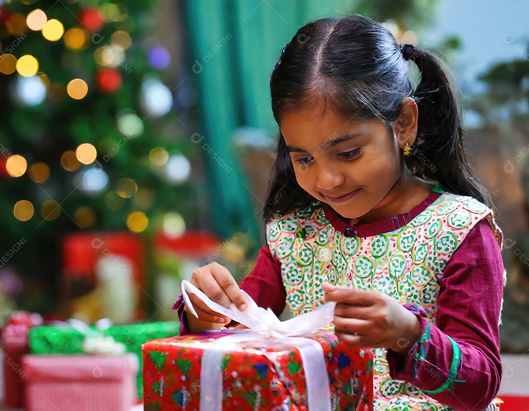 Criança asiática feliz desembrulhando um presente no natal