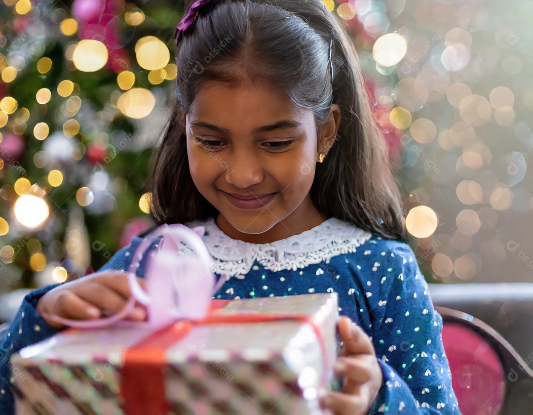 Criança asiática feliz desembrulhando um presente no natal