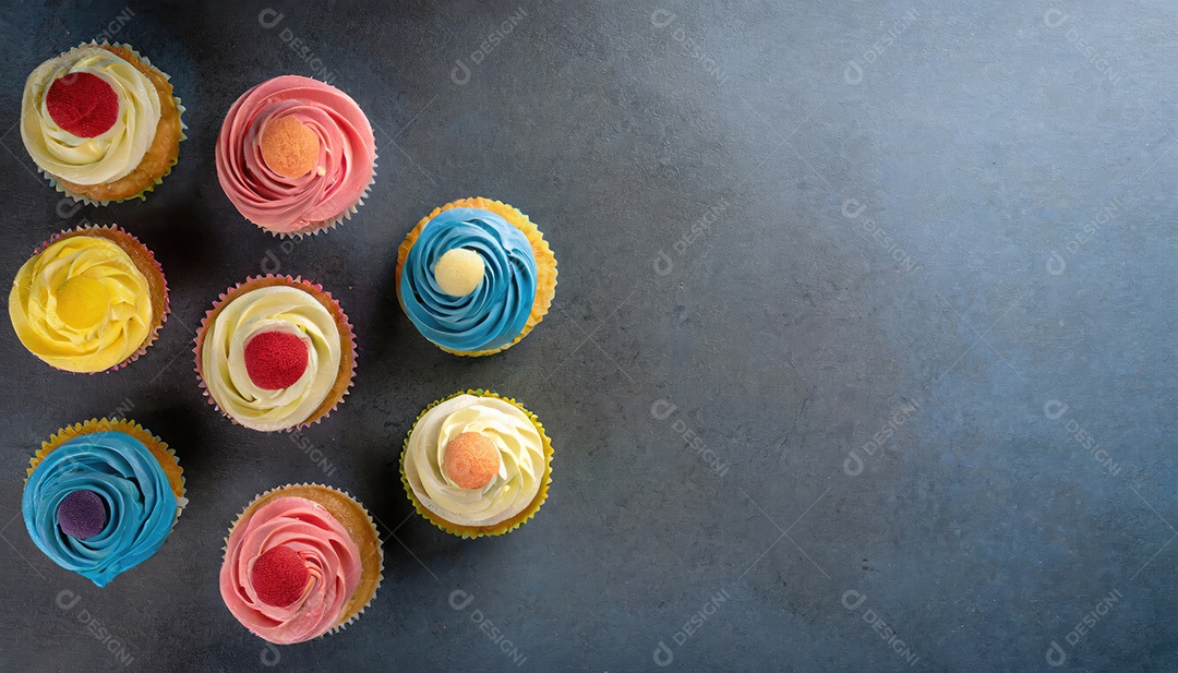 Bolinhos saborosos na mesa escura. Vista superior do bolo colorido