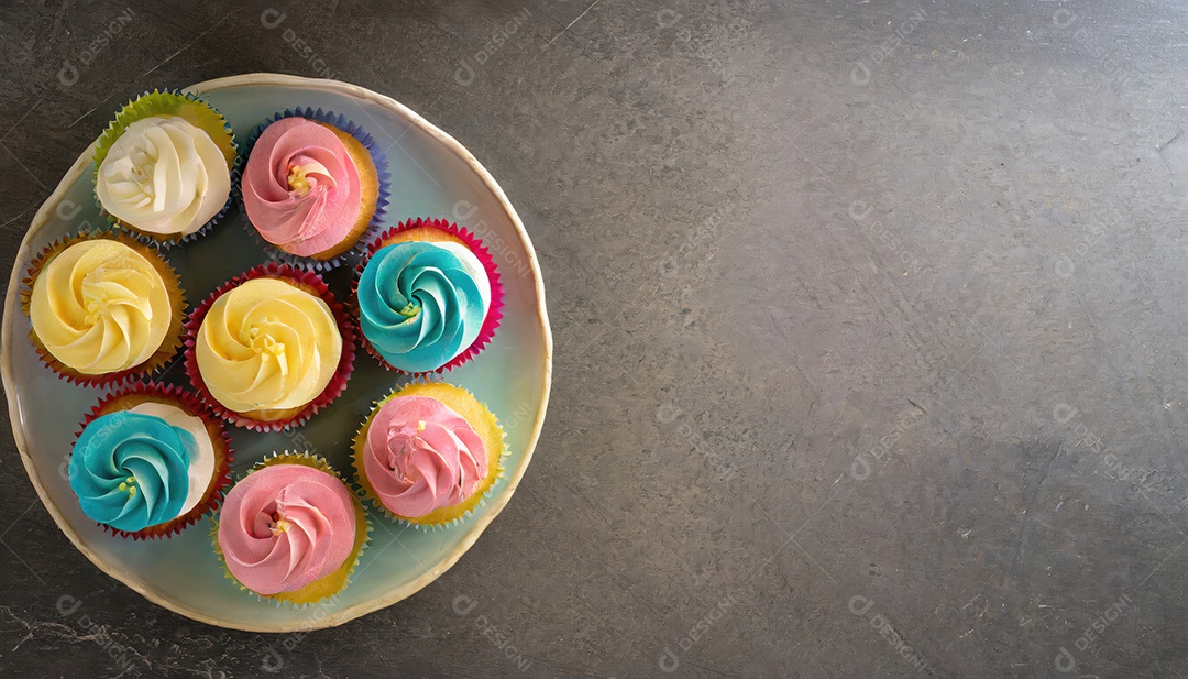 Bolinhos saborosos na mesa escura. Vista superior do bolo colorido