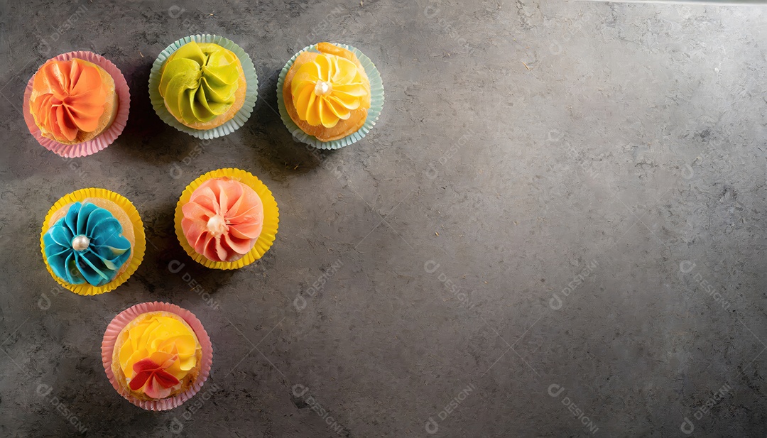 Bolinhos saborosos na mesa escura. Vista superior do bolo colorido