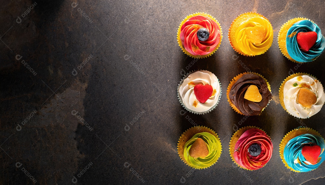 Bolinhos saborosos na mesa escura. Vista superior do bolo colorido