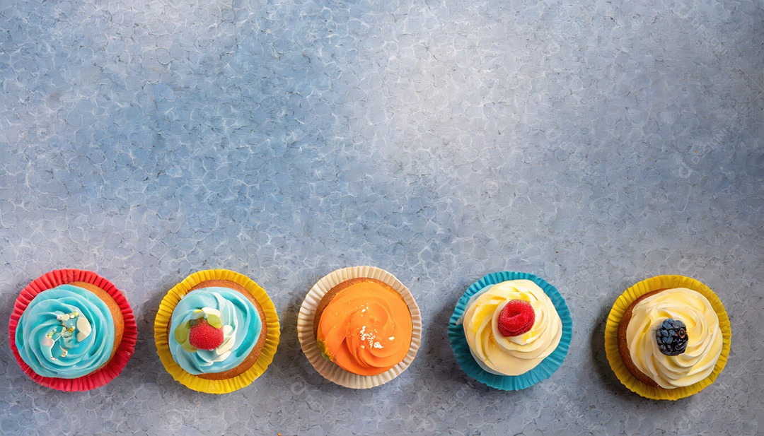 Bolinhos saborosos na mesa escura. Vista superior do bolo colorido