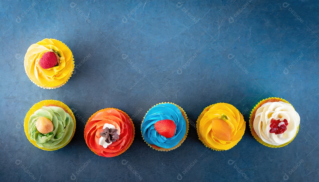 Bolinhos saborosos na mesa escura. Vista superior do bolo colorido