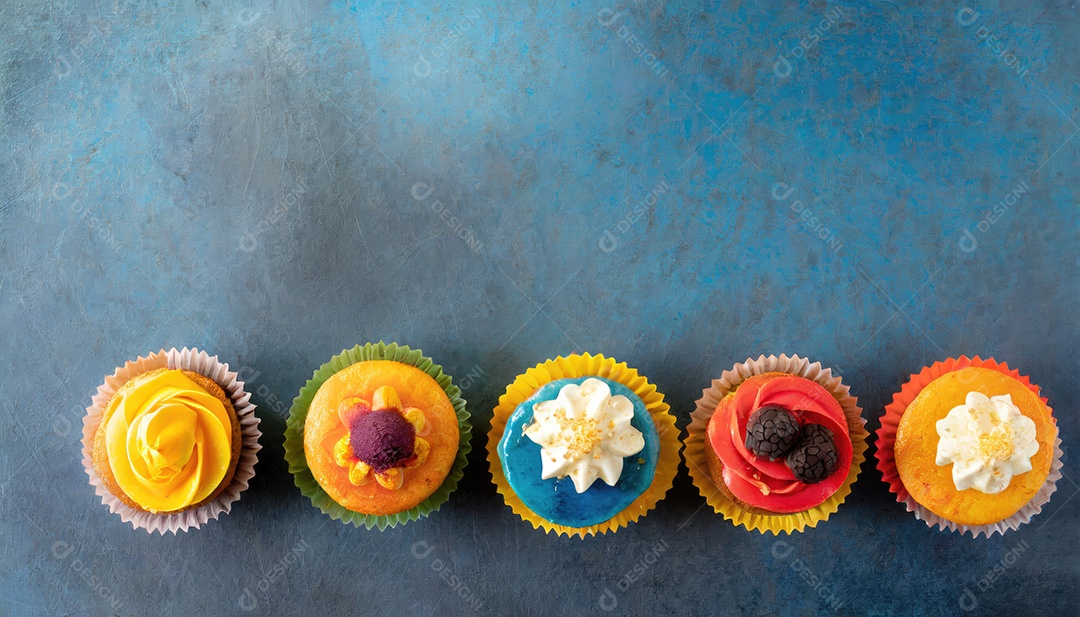 Bolinhos saborosos na mesa escura. Vista superior do bolo colorido