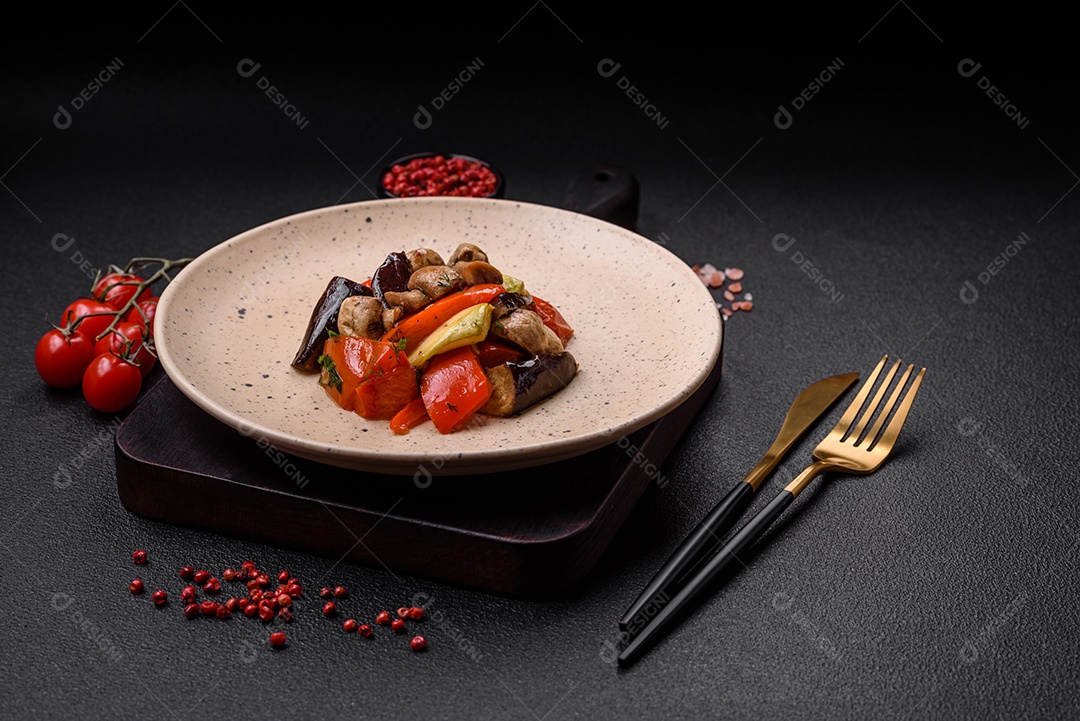 Deliciosa salada de legumes grelhados, tomates, cogumelos, pimentões, berinjelas, abobrinha, sal, especiarias e ervas em um prato cerâmico
