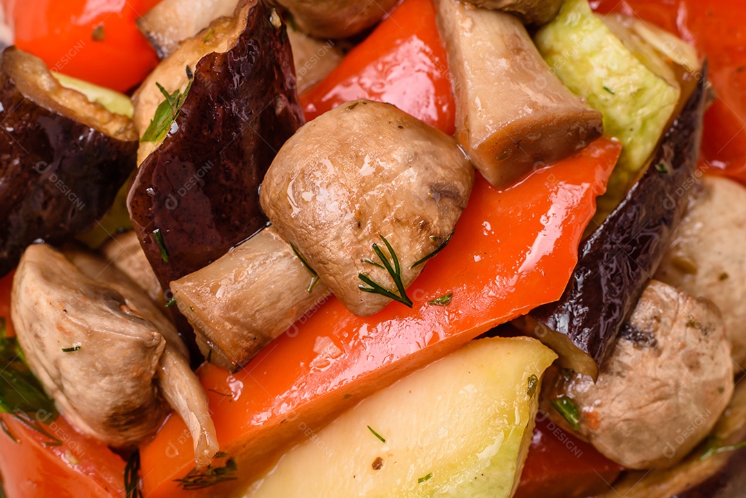 Deliciosa salada de legumes grelhados, tomates, cogumelos, pimentões, berinjelas, abobrinha, sal, especiarias e ervas em um prato cerâmico