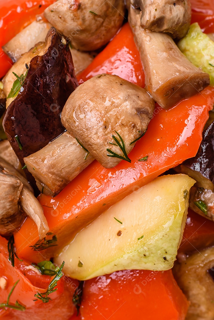 Deliciosa salada de legumes grelhados, tomates, cogumelos, pimentões, berinjelas, abobrinha, sal, especiarias e ervas em um prato cerâmico