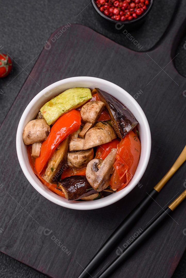 Deliciosa salada de legumes grelhados, tomates, cogumelos, pimentões, berinjelas, abobrinha, sal, especiarias e ervas em um prato cerâmico