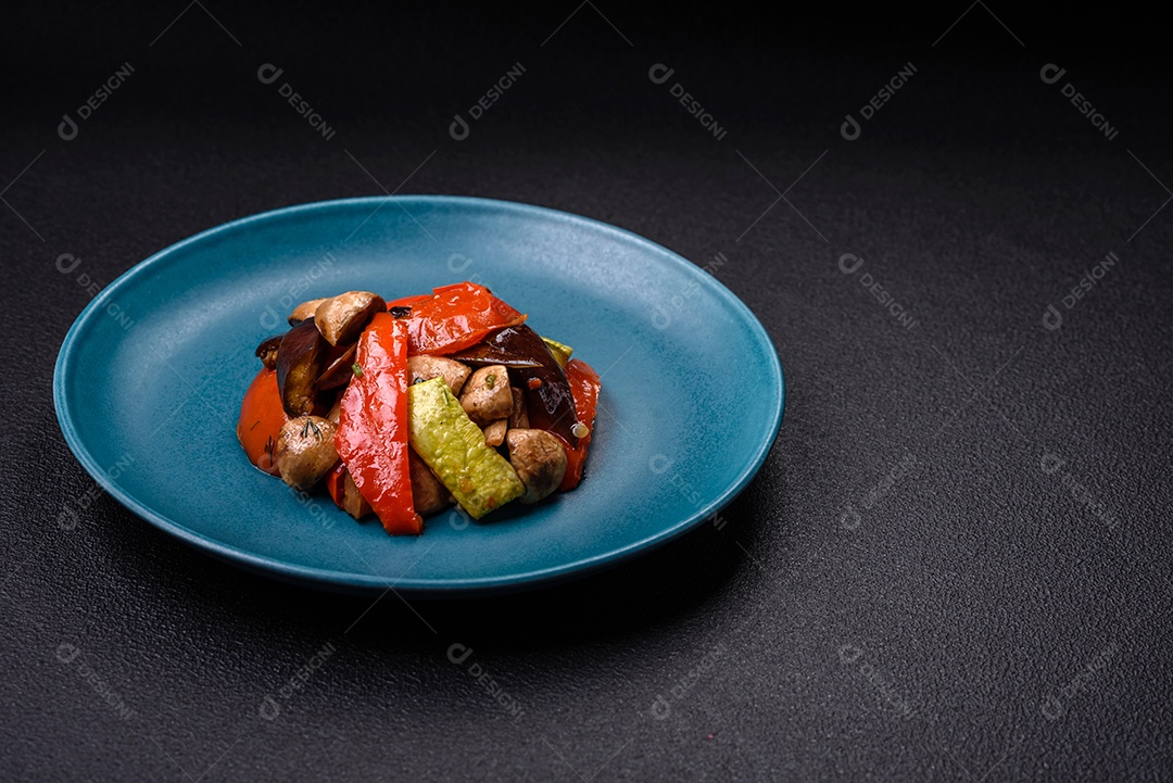 Deliciosa salada de legumes grelhados, tomates, cogumelos, pimentões, berinjelas, abobrinha, sal, especiarias e ervas em um prato cerâmico