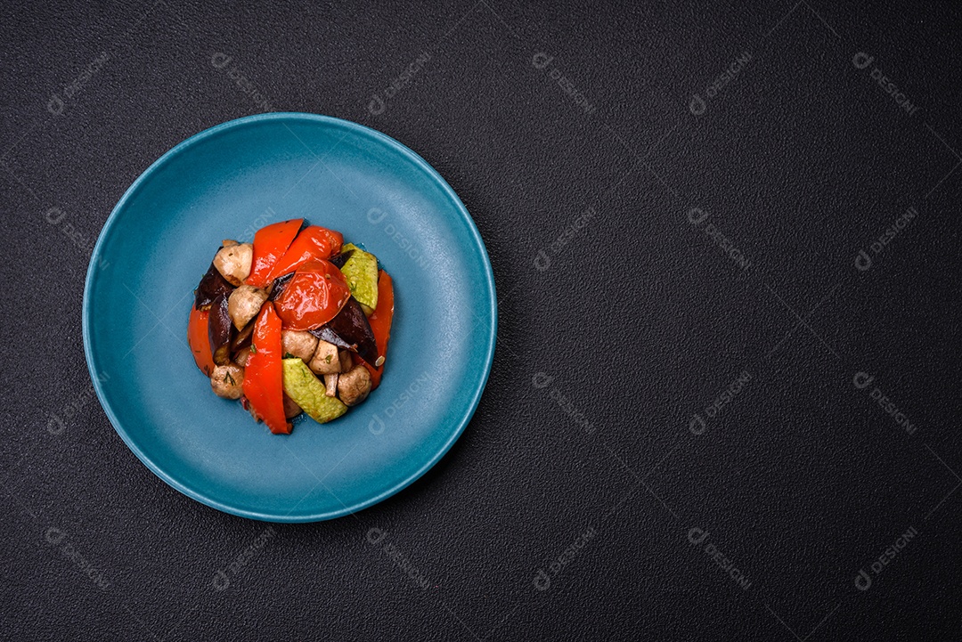 Deliciosa salada de legumes grelhados, tomates, cogumelos, pimentões, berinjelas, abobrinha, sal, especiarias e ervas em um prato cerâmico