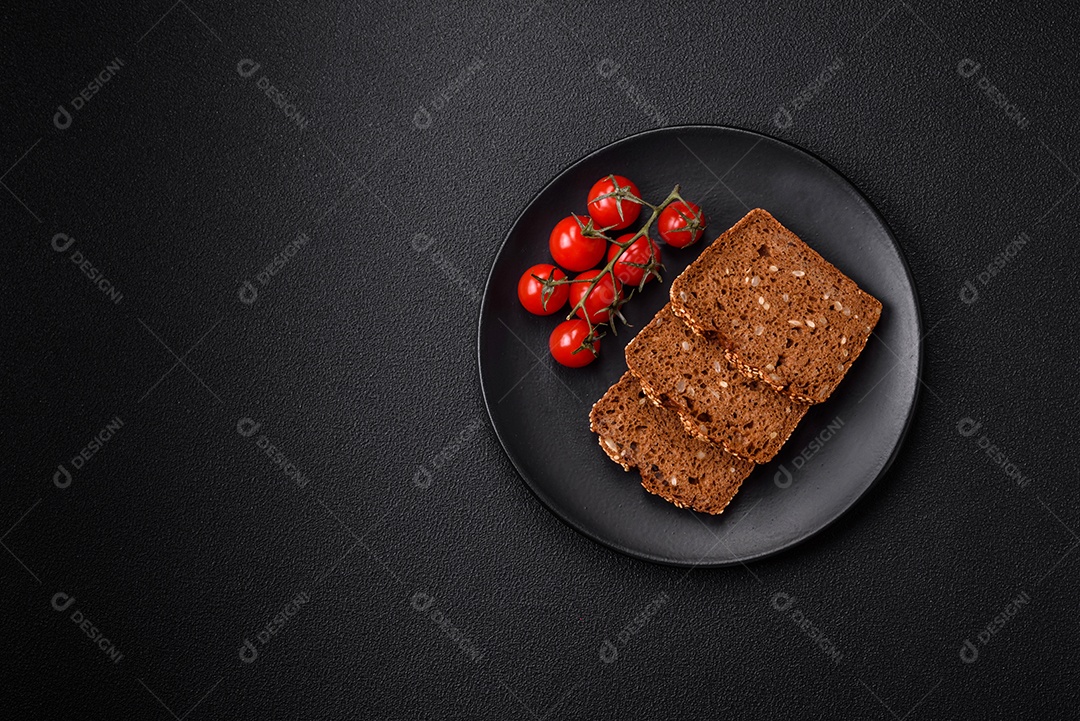 Delicioso pão integral crocante fresco com sementes e grãos sobre um fundo escuro de concreto