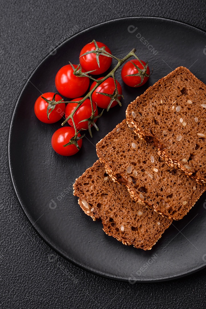 Delicioso pão integral crocante fresco com sementes e grãos sobre um fundo escuro de concreto