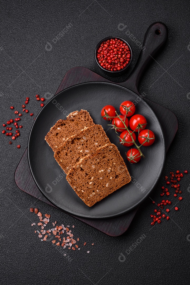 Delicioso pão integral crocante fresco com sementes e grãos sobre um fundo escuro de concreto