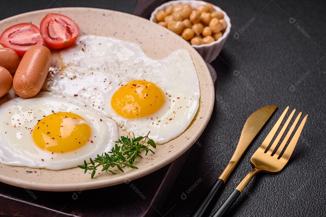 Ovos de galinha fritos, salsichas, tomate cereja, grão de bico, especiarias, sal e ervas. Delicioso café da manhã nutritivo