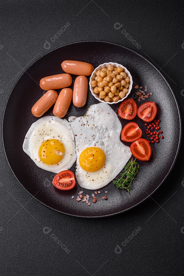 Ovos de galinha fritos, salsichas, tomate cereja, grão de bico, especiarias, sal e ervas. Delicioso café da manhã nutritivo