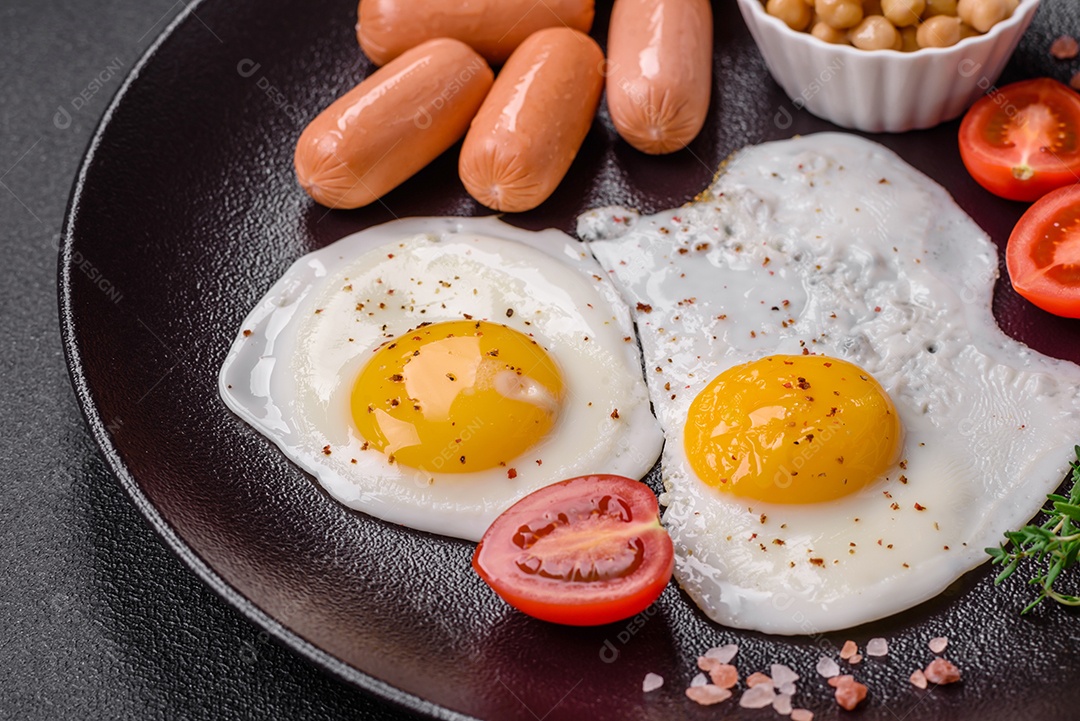 Ovos de galinha fritos, salsichas, tomate cereja, grão de bico, especiarias, sal e ervas. Delicioso café da manhã nutritivo