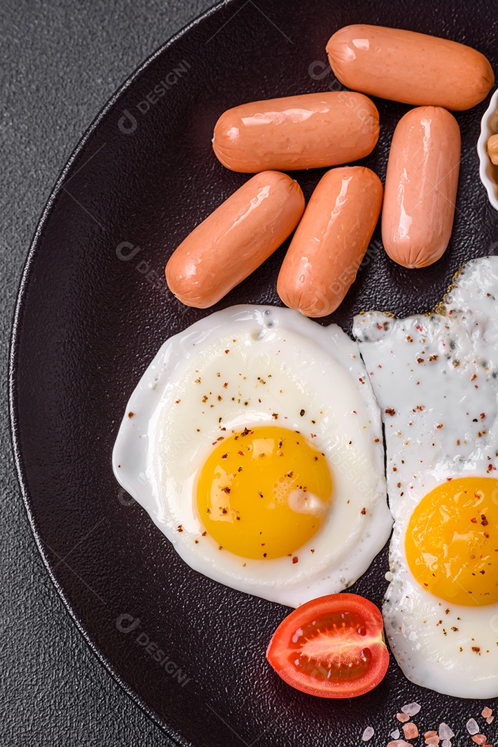 Ovos de galinha fritos, salsichas, tomate cereja, grão de bico, especiarias, sal e ervas. Delicioso café da manhã nutritivo