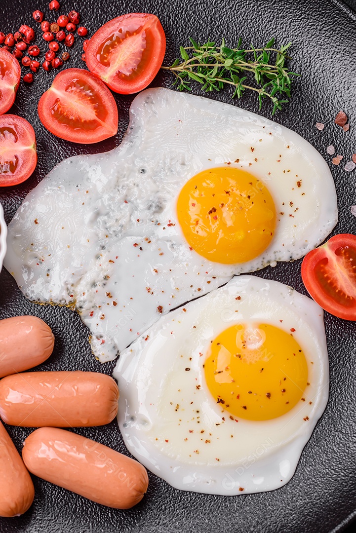 Ovos de galinha fritos, salsichas, tomate cereja, grão de bico, especiarias, sal e ervas. Delicioso café da manhã nutritivo