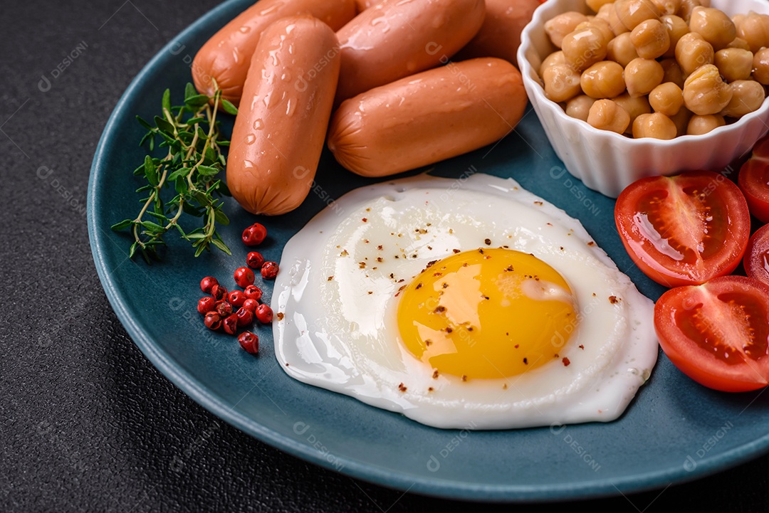 Ovos de galinha fritos, salsichas, tomate cereja, grão de bico, especiarias, sal e ervas. Delicioso café da manhã nutritivo