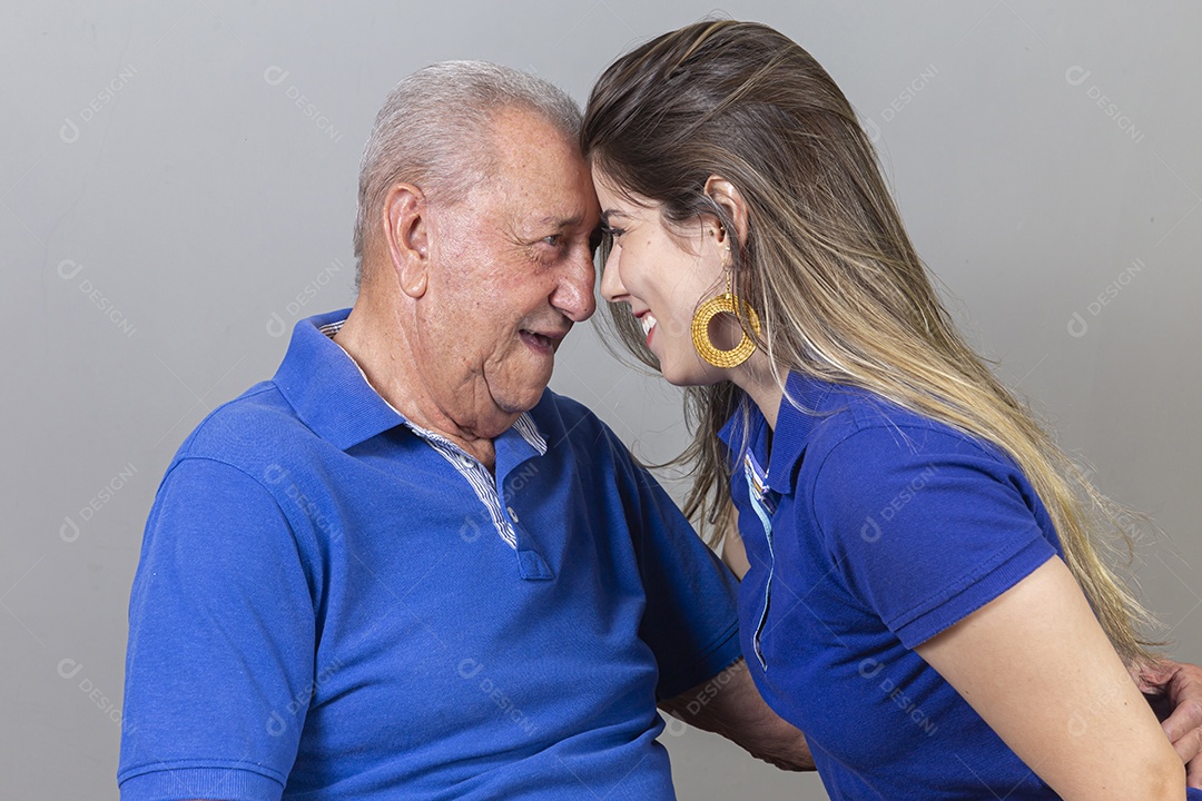 Homem idoso e jovem mulher combinando de camiseta azul