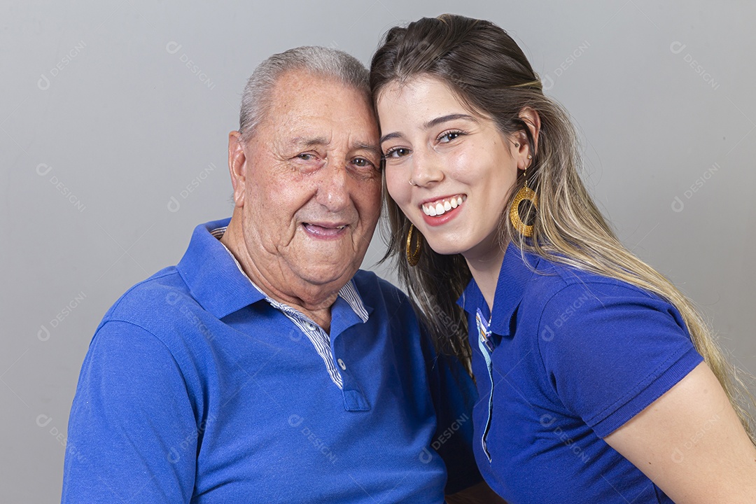 Homem idoso e jovem mulher combinando de camiseta azul