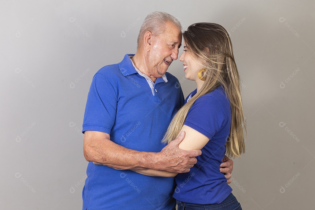 Homem idoso e jovem mulher combinando de camiseta azul