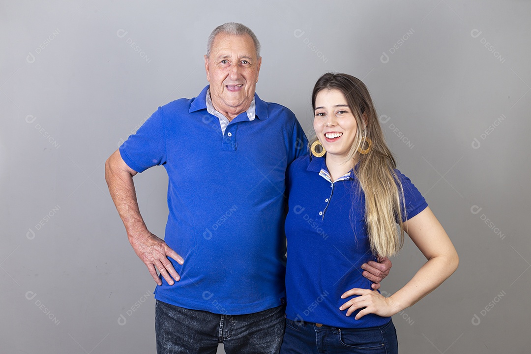 Homem idoso e jovem mulher combinando de camiseta azul