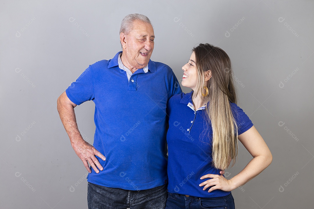 Homem idoso e jovem mulher combinando de camiseta azul