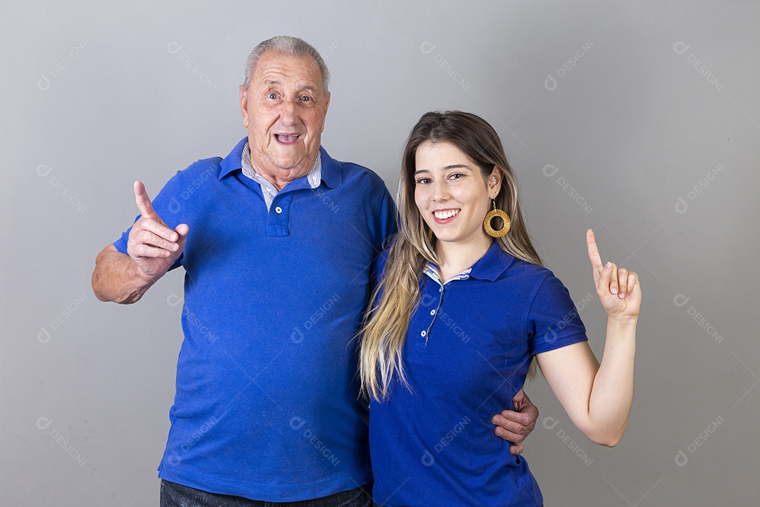 Homem idoso e jovem mulher combinando de camiseta azul