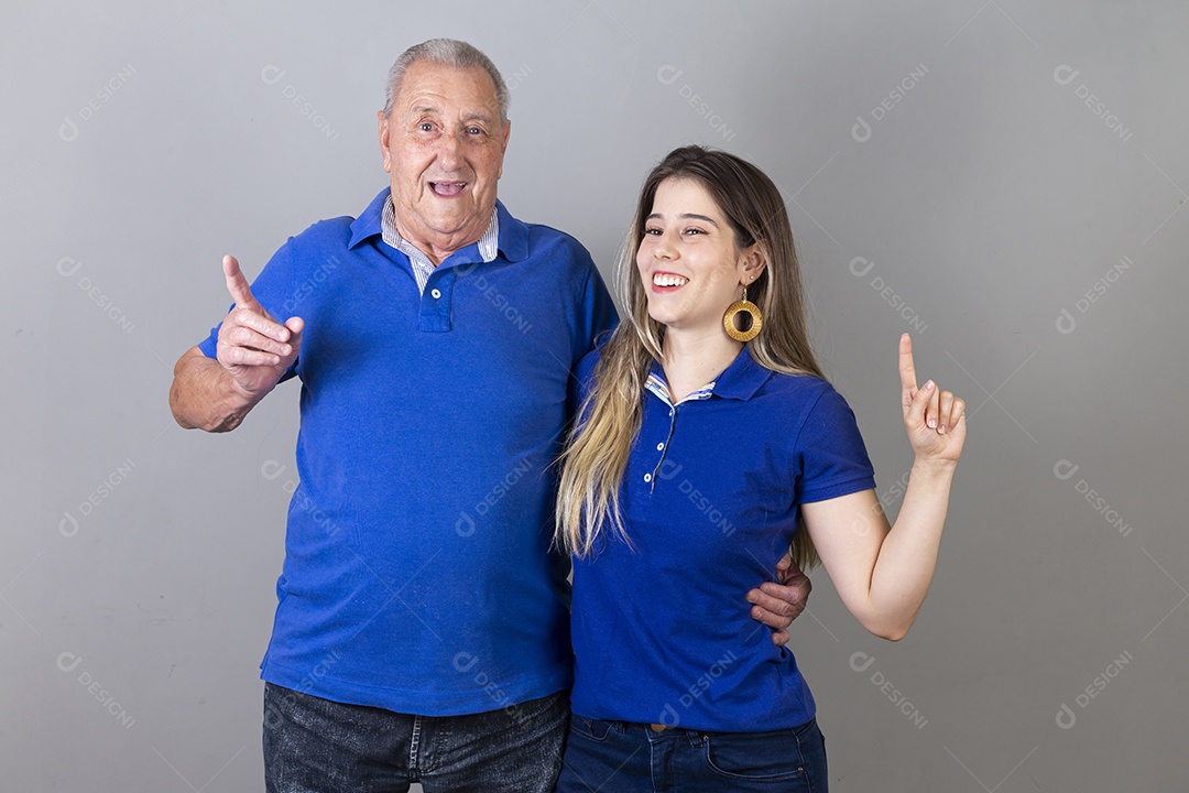 Homem idoso e jovem mulher combinando de camiseta azul